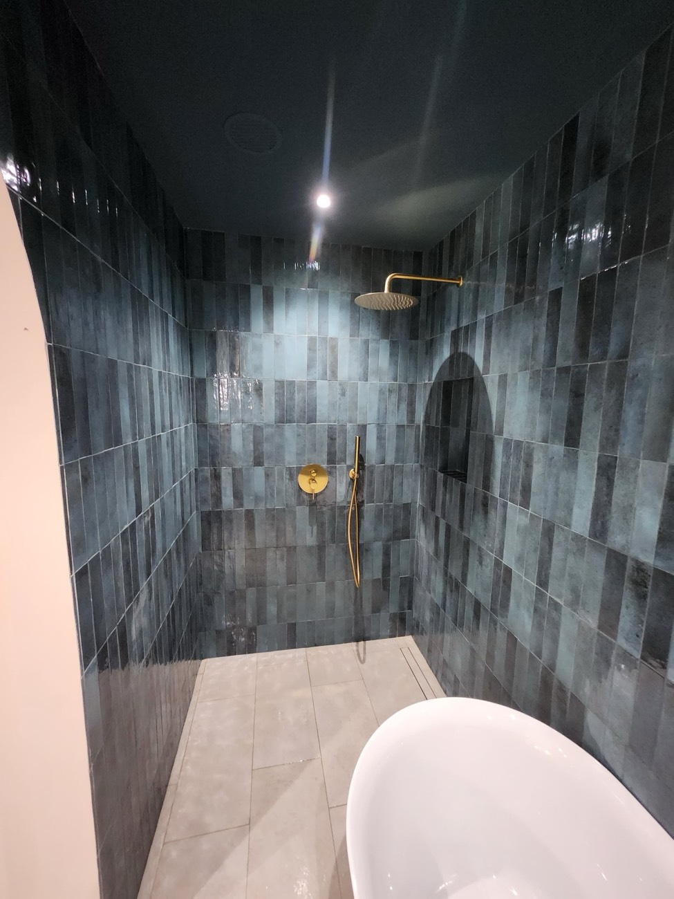 Shower area with tiled ceiling and an arched niche