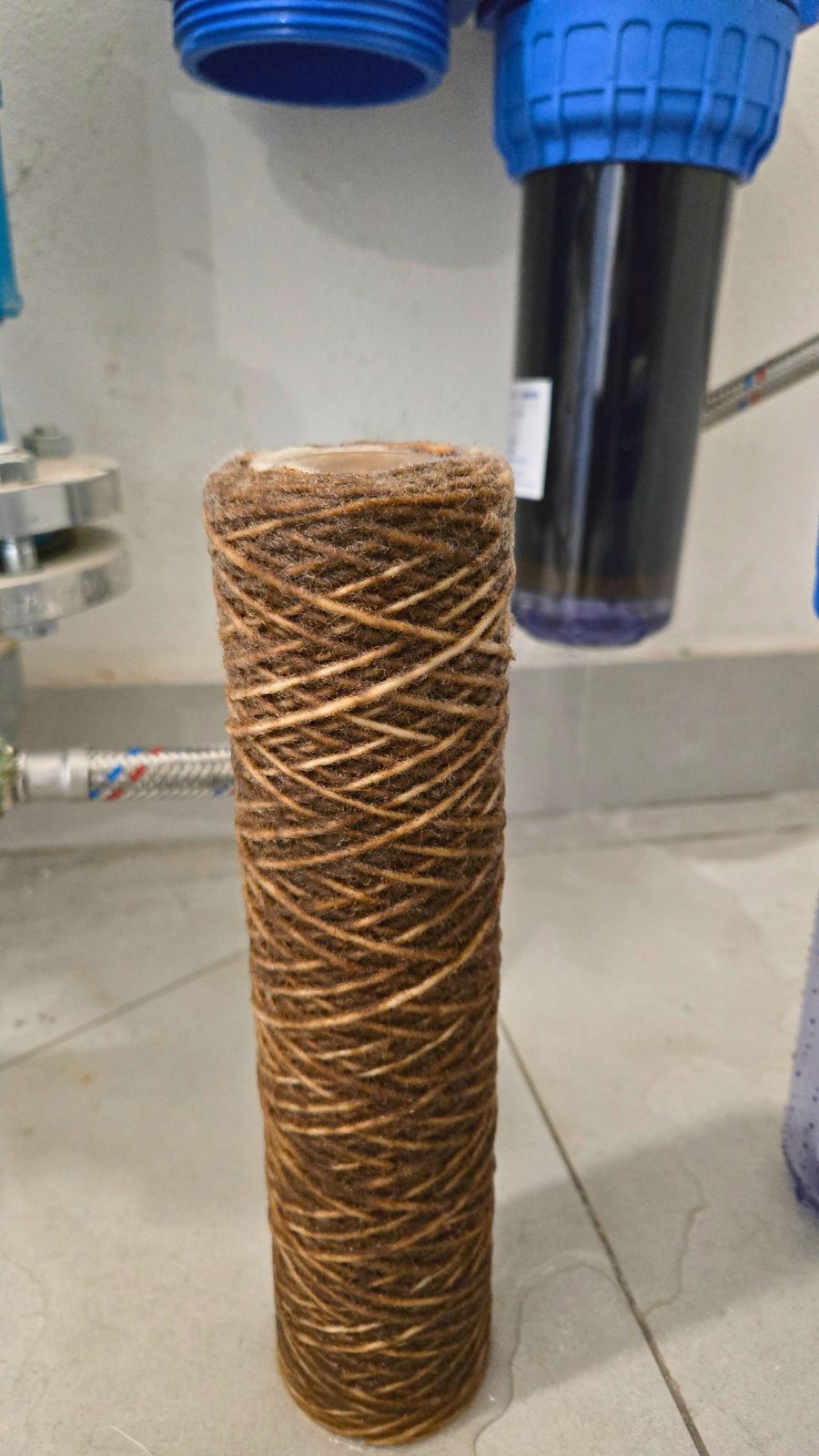 A sediment cartridge after six months of use, stained brown by what it has collected